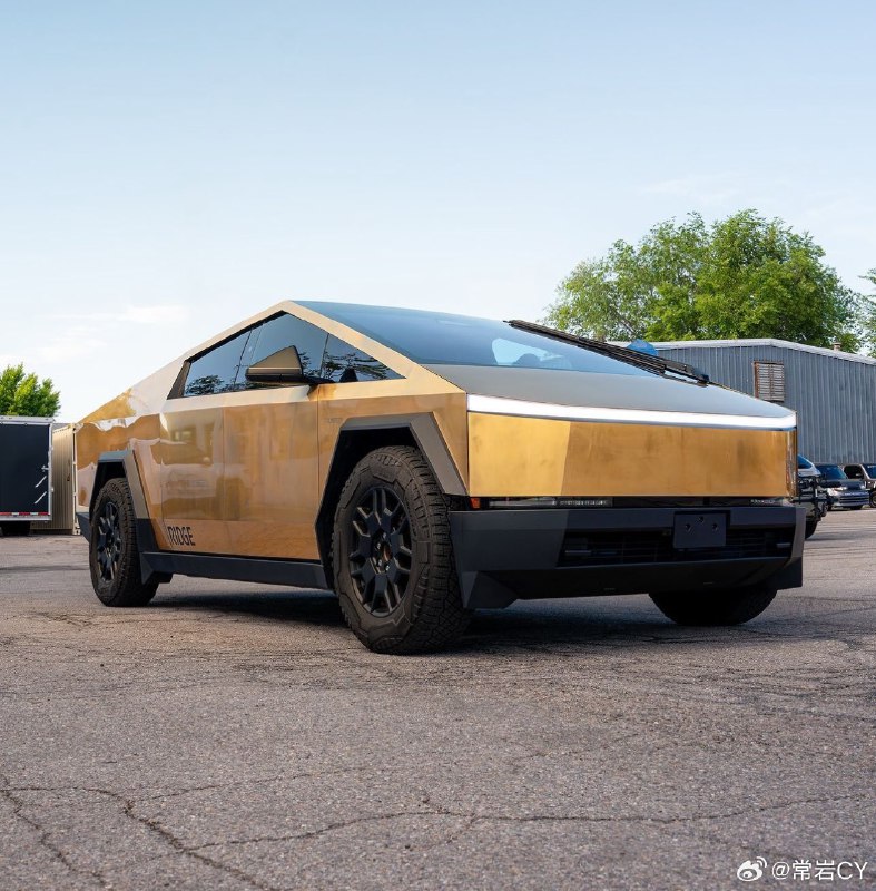 这辆 Cybertruck 车身上镀上了 24K 的黄金，并罩上了车衣。配图